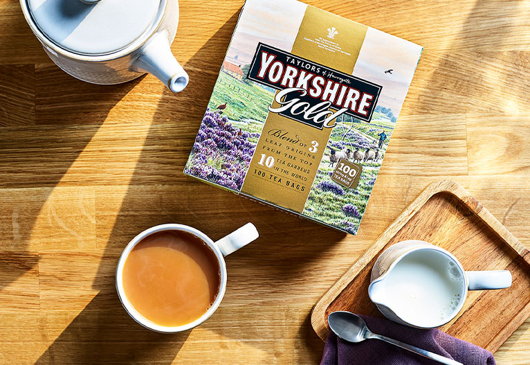 Box of Yorkshire tea on a table next to a mug of tea.