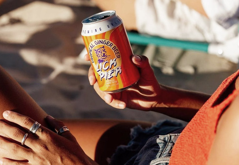 Woman holding Lick Pier ginger beer can.