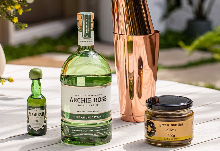 Archie Rose Signature Dry Gin on a table with cocktail accessories.