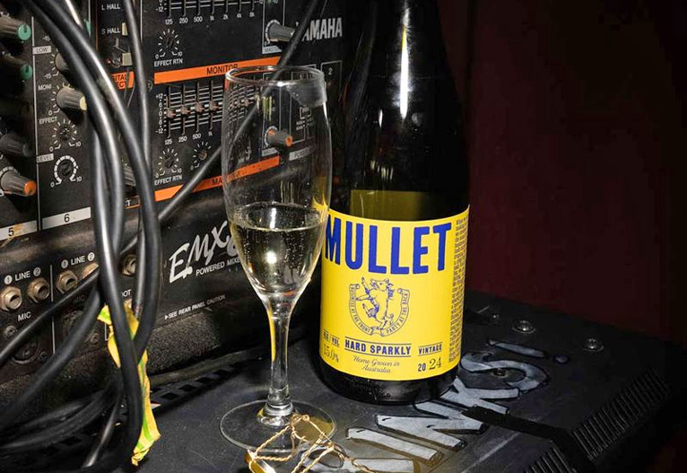 Mullet hard sparkly wine bottle next to a stereo.