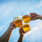 Beer glasses held up for cheers.