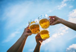 Beer glasses held up for cheers.