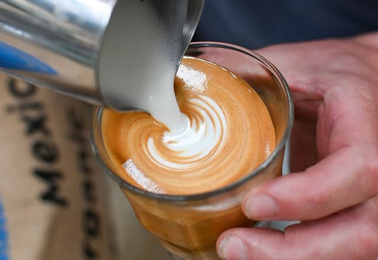 Pouring milk into premium decaf coffee.