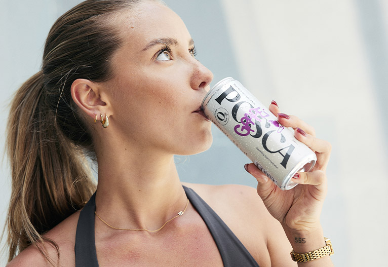 Woman sipping a sports drinks from a can.