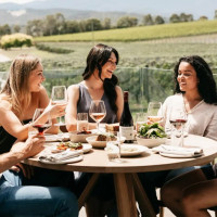 Group of people dining at Oakridge Yarra Valley winery outside.