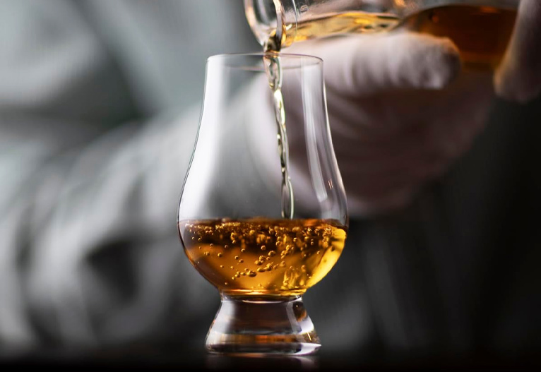Pouring whisky into Glencairn official whisky nosing glass.