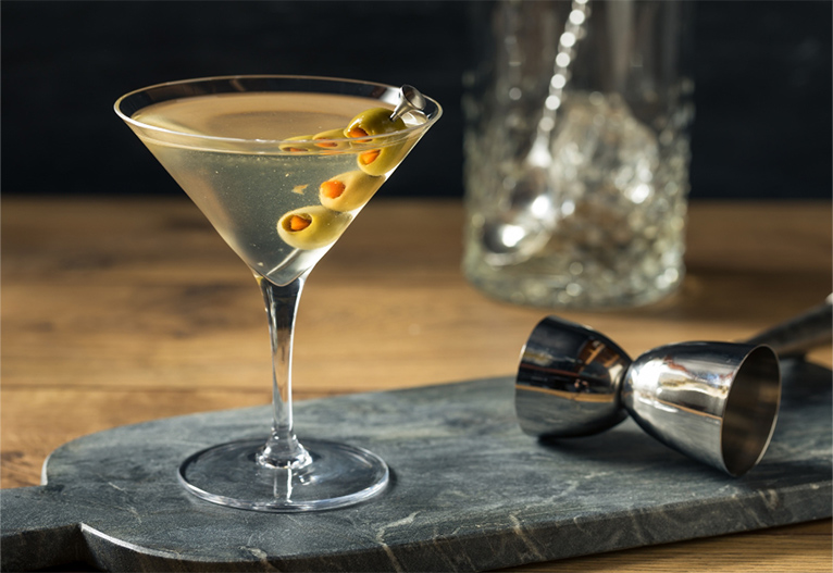 Classic three-olive martini on a marble paddle board.