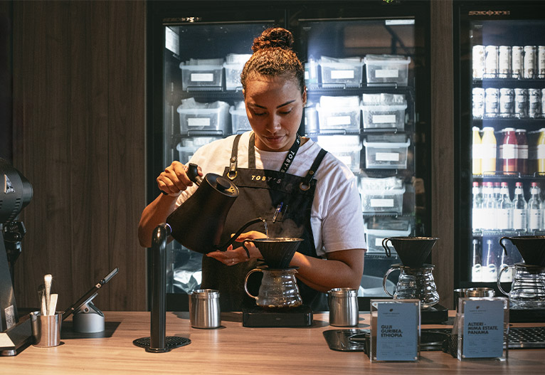 Barista, Fernanda, preparing coffee at Toby's Estate.