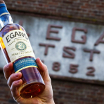 Hand holding up a bottle of Egan's Fortitude Whiskey.