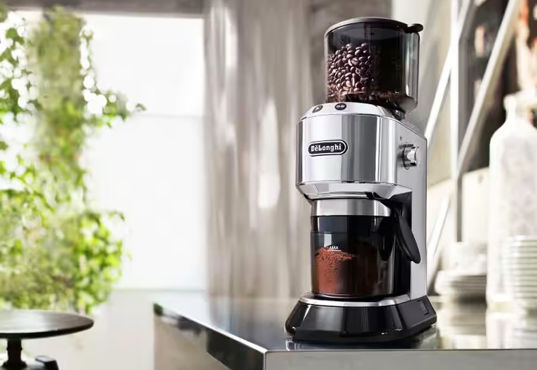 DeLonghi electric Dedica coffee grinder on a kitchen bench.