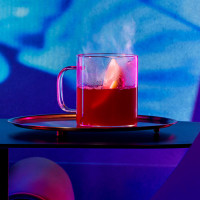 Hot toddy cocktail on a bench amidst blue light.