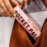 Person putting El Toro Paloma Pocket Cocktail into a handbag.