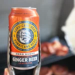 Can of Hurricane Zero Sugar Alcoholic Ginger Beer held with a pair of tongs.