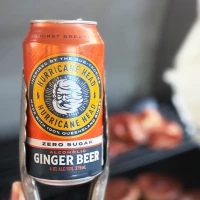 Can of Hurricane Zero Sugar Alcoholic Ginger Beer held with a pair of tongs.