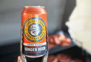 Can of Hurricane Zero Sugar Alcoholic Ginger Beer held with a pair of tongs.
