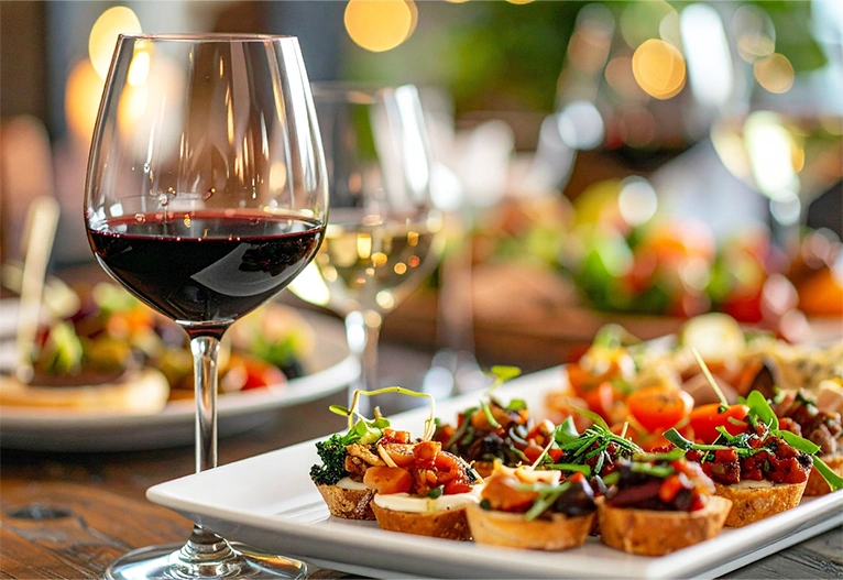 Wine glasses on a table with canapes.