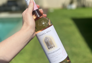 Person holding a bottle of Chapel Hill Enlightened Rosé.