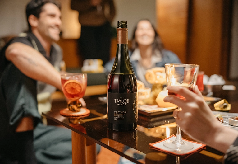 People sitting around a table drinking red wine.