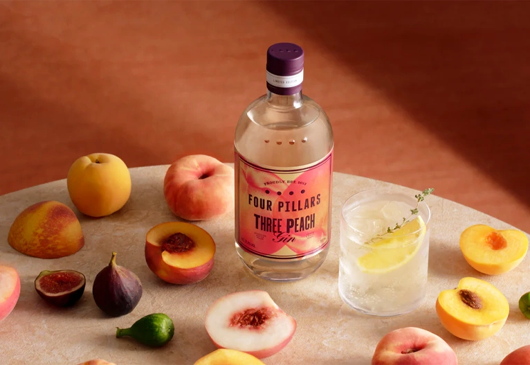 Three Peach Gin and ingredients on a table.
