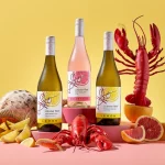 Lobster Reef Flavours wines on a table with seafood and citrus fruit.